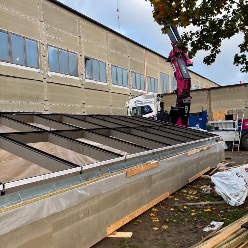 Den nye vindueskonstruktion ligger klar på jorden foran biblioteket.