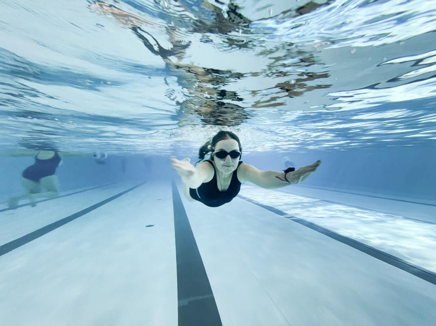 Kvinde svømmer under vandet.