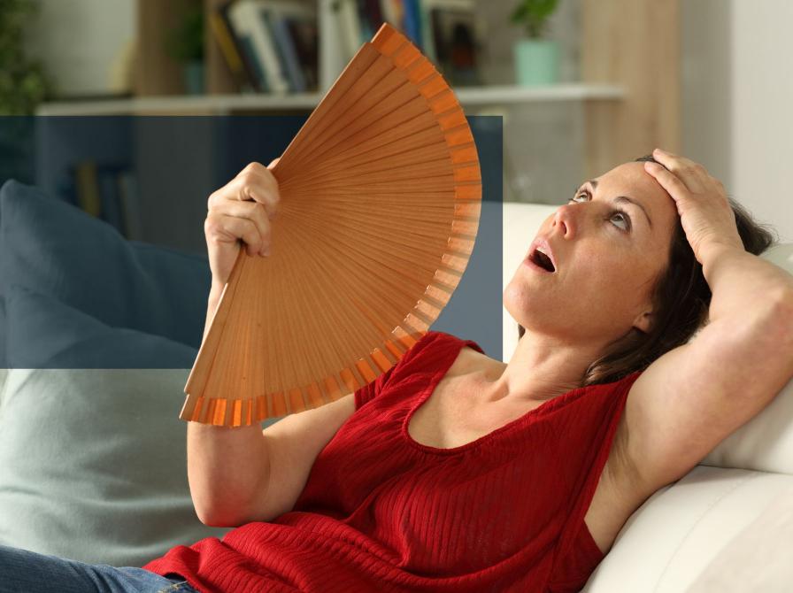 Kvinde som har det varmt og køle sig ned med en vifte